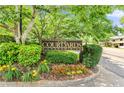 Well-maintained community entrance sign surrounded by mature trees and colorful landscaping at 472 Sherman Way, Decatur, GA 30033