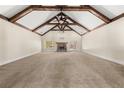 Open-concept living room with vaulted ceilings, exposed beams, and stone fireplace at 90 Alcovy Reserve Way, Covington, GA 30014