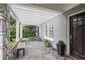 Charming covered porch with stone floor, bench seating, and view of the front yard at 635 Wilson Nw Rd, Atlanta, GA 30318