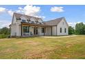 Gorgeous home showcasing its covered front porch, black framed windows, vertical siding, and sprawling front lawn at 1423 Hillcrest Rd, Bowdon, GA 30108