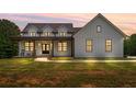 Charming home featuring vertical siding, a welcoming front porch, dark window frames, and ample outdoor space at 1423 Hillcrest Rd, Bowdon, GA 30108
