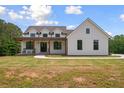 Beautiful home with a covered front porch, dark framed windows, vertical siding, and well-maintained lawn at 1423 Hillcrest Rd, Bowdon, GA 30108