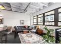 Cozy living room with black painted floor, large windows, and a comfortable gray sofa at 878 Peachtree Ne St # 634, Atlanta, GA 30309
