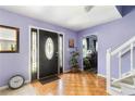Inviting foyer featuring hardwood floors, a stylish black front door, and a staircase at 1956 Spencer Oaks Ln, Lithonia, GA 30058
