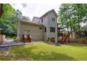 Back exterior featuring a wooden deck with stairs leading to the yard, surrounded by lush greenery at 2370 Burch Cir, Brookhaven, GA 30319