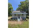 Charming single-story home with a quaint front porch with plants, inviting curb appeal and a lovely garden area at 5108 Hackett Ne St, Covington, GA 30014