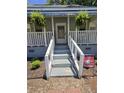 Close up of Front Porch. A quaint front porch with hanging plants and garden and a welcoming entrance at 5108 Hackett Ne St, Covington, GA 30014