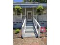 Close up on the front porch and entrance with a cheerful 'hello' sign and a patriotic Bulldogs flag at 5108 Hackett Ne St, Covington, GA 30014