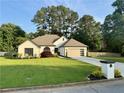 Well-maintained single-story home featuring an attached two-car garage, beautiful yard and mature trees at 2610 Stokesley Way, Snellville, GA 30078