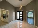 Bright foyer with modern light fixture, frosted glass front door, and marble tile flooring at 2610 Stokesley Way, Snellville, GA 30078