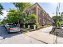 Multi-story brick exterior featuring mature trees and landscaping around the property, with on-street parking available at 733 Frederica Ne St # 17, Atlanta, GA 30306