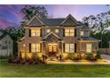Beautifully illuminated exterior of a two-story brick home at dusk, enhancing its architectural details at 771 Phil Haven Ln, Kennesaw, GA 30152