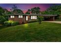 Charming brick home with a well-manicured lawn and covered carport at dusk at 14 Connie St, Cartersville, GA 30121