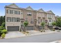 Charming townhome row featuring brick facade, two-car garages, and meticulously kept front yards at 1582 Cambridge Pl, Marietta, GA 30062