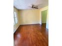 Living room with hardwood floors, yellow walls, ceiling fan, and a window with natural light at 801 Needle Rock Dr, Stone Mountain, GA 30083
