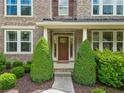 Welcoming front entrance with a classic wood door framed by manicured greenery and elegant columns at 111 Millstone Way, Canton, GA 30115