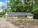 Exterior shot of a white home with a dark roof and green trees at 1110 Upper Hembree Rd, Roswell, GA 30076