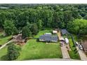 Aerial shot showcasing a property with a large, manicured lawn, detached garage, and ample parking at 140 Wilbanks St, Buford, GA 30518
