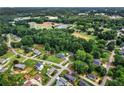 A high angle shows homes surrounded by trees, utilities and open land in a quiet residential neighborhood at 140 Wilbanks St, Buford, GA 30518