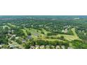 Scenic aerial view of a lush green golf course surrounded by trees and residential homes at 6695 Buckingham Cir, Cumming, GA 30040