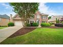 Attractive brick home featuring an attached garage and manicured landscaping, adding to its charm at 6695 Buckingham Cir, Cumming, GA 30040