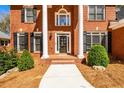 Welcoming front entrance with white pillars and a brick walkway leading to the door at 1105 River Laurel Dr, Suwanee, GA 30024