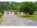 Exterior view showing the house with a spacious cracked driveway and a mature tree at 624 Lyle Se Dr, Marietta, GA 30067