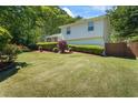 Exterior side view featuring a well-maintained lawn, a manicured landscape, and a wooden fence at 1007 Wayne Dr, Snellville, GA 30078