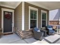 Close-up of the cozy front porch with rocking chairs, stone accents, and a welcoming wreath on the front door at 2657 Cedar Pine Way, Atlanta, GA 30360