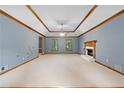 Spacious living area with a fireplace, neutral carpet, tray ceilings, and electrical outlets on the wall at 2865 Bryant Ct, Cumming, GA 30040