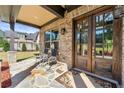 Inviting front porch with stone flooring, rocking chairs, and a view of the well-maintained front yard at 704 Rock Springs Rd, Lawrenceville, GA 30043