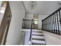 Inviting entryway showcasing elegant black railings, chandelier, and a glimpse of the kitchen at 710 Singing Hills Ct, Roswell, GA 30076