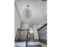 Elegant entryway featuring a chandelier and modern railings, offering a glimpse into the kitchen at 710 Singing Hills Ct, Roswell, GA 30076