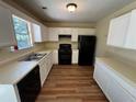 Functional kitchen featuring white cabinets, black appliances and ample counter space at 1050 Redan Trce, Stone Mountain, GA 30088