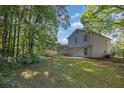 Spacious backyard featuring lush greenery and a partial view of the home's exterior at 6541 Lazy Creek Ct, Lithonia, GA 30058