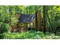 Exterior home view nestled among trees and lush foliage, with the front entrance and wooden steps visible at 3246 Able Ct, Marietta, GA 30062
