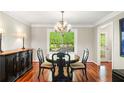 Dining room with chandelier, hardwood floors, black buffet, and a large window overlooking the backyard at 4108 Berryhill Se Trce, Smyrna, GA 30082
