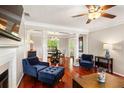 Open living room featuring hardwood floors, fireplace, columns, and adjacent dining area with modern chandelier at 4108 Berryhill Se Trce, Smyrna, GA 30082
