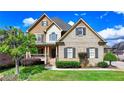 Charming home showcasing a well-kept lawn, brick exterior, and cozy covered entryway at 1054 Morgan Garner Sw Dr, Lilburn, GA 30047