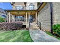 Inviting front porch with classic columns, brick accents, and well-maintained landscaping at 1054 Morgan Garner Sw Dr, Lilburn, GA 30047