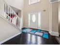 Welcoming foyer featuring a staircase, elegant front door with sidelights, and sleek hardwood floors at 1592 Smithson Ct, Lithonia, GA 30058