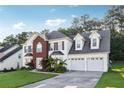 Inviting two-story house with a two-car garage, brick accent, and a lush green lawn under a sunny sky at 1592 Smithson Ct, Lithonia, GA 30058