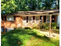 Inviting brick home featuring a landscaped front yard, complemented by lush greenery and a garden light at 5582 Brady Dr, Stone Mountain, GA 30087