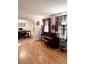 Bright living room boasting hardwood floors, complemented by a piano and views into the dining area at 5582 Brady Dr, Stone Mountain, GA 30087
