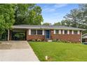 Brick home with a well-kept lawn, stylish landscaping, and a convenient carport at 2521 Whites Mill Ln, Decatur, GA 30032