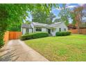 Landscaped front yard with white painted brick home, dark trim and solar panels on the roof at 3734 Powers Ferry Nw Rd, Atlanta, GA 30342