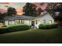 Charming white brick home with black trim and solar panels at dusk provides curb appeal at 3734 Powers Ferry Nw Rd, Atlanta, GA 30342