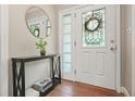 Inviting foyer features a decorative glass door and a stylish console table with a round mirror at 3734 Powers Ferry Nw Rd, Atlanta, GA 30342