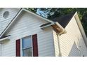 Image shows the home's siding and trim with its red shutters and window at 5415 Twin Lakes Dr, Atlanta, GA 30349