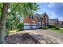 Beautiful brick home with manicured lawn, two-car garage, and mature trees at 1124 Monarda Nw Way, Acworth, GA 30102